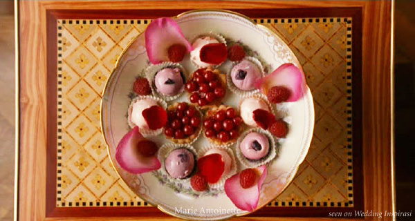 Light pink macarons, berry tarts, rose petals for a pink wedding tea party